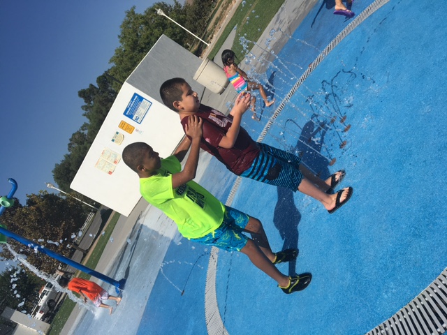 Two boys playing in a fountain