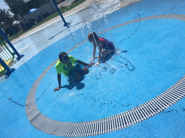 A boy and a girl sitting in one of the fountains