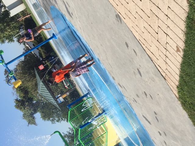 A boy and little girl playing in one of the fountains