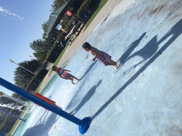 Two girls about to get soaked by a small tipping bucket