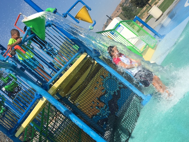 A boy getting soaked by a tipping bucket