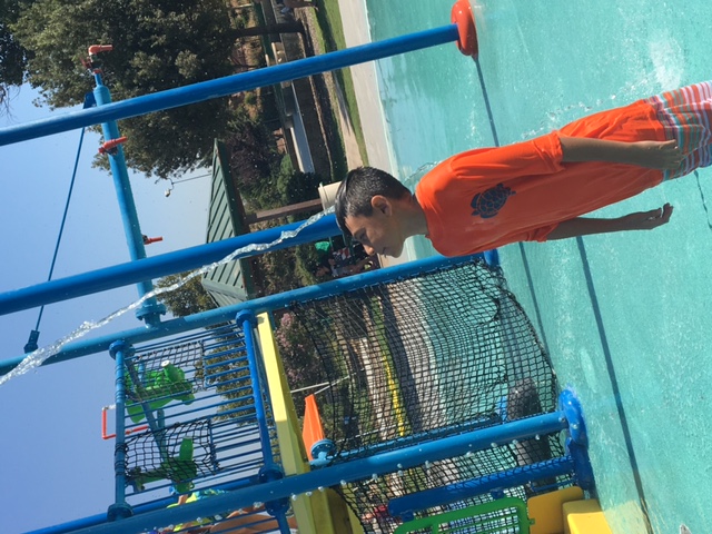 A boy feeling a stream of water on his forhead