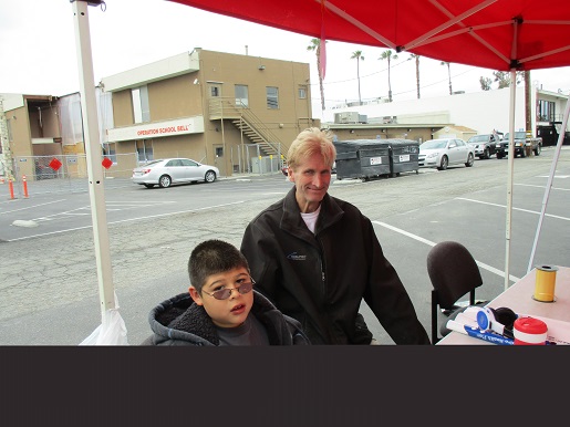 A boy and his father helping with the booth