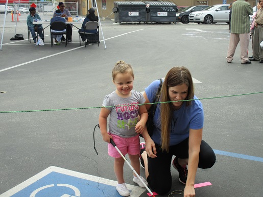 a blind child with her mother at the ring toss
