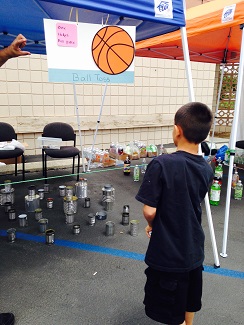 A kid tossing a ball in the ball toss booth