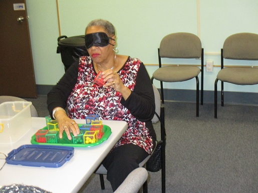 A woman is trying to do the tasks at the sensory day event.
