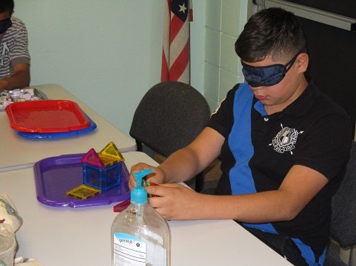 A child is blind folded and asked to perform a task as a blind person