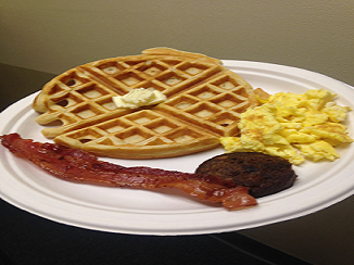 a plate of pancakes, eggs and bacon.