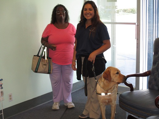 A trainer and a person are coming back from walking the service animal