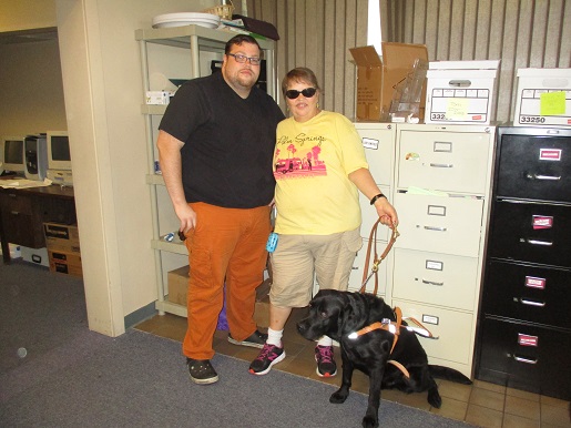 Teresa and her son Clint are standing with Chuck the Guide Dog