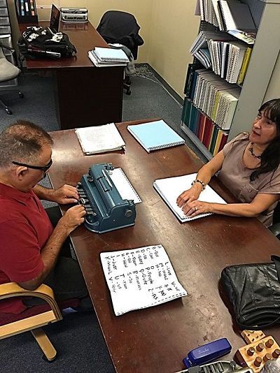 Sal is being taught Braille by Christine Davidson.