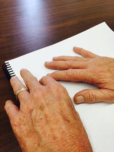 Darell reading Braille with two hands
