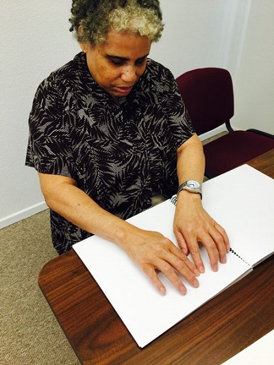 A student is reading Braille with her fingers.