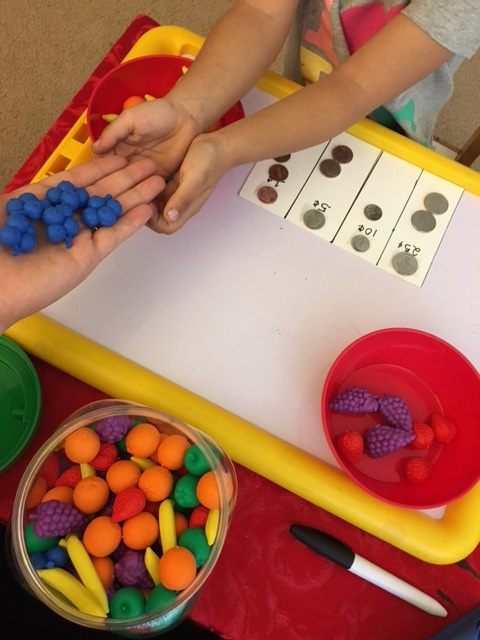 Using small plastic fruit to learn how to count