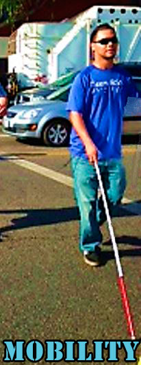 Feliciano walking across the street with his white cane