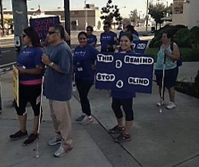 A group of blind walkers with signs raising awarenes of driving while distracted