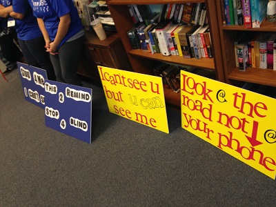 demonstration signs to raise awarenes about driving and not paying attention to people with white canes