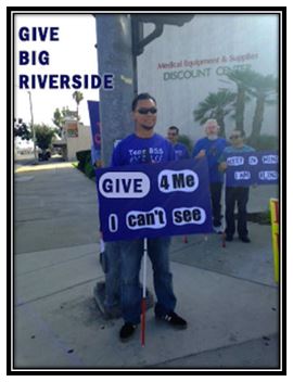Feliciano with a sign for Give Big saying Give for Me I can't see