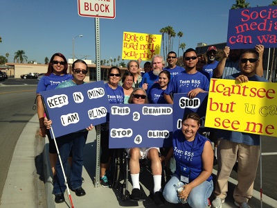 BSS walking the streets with white canes and signs to raise awarenes of driving while distracted