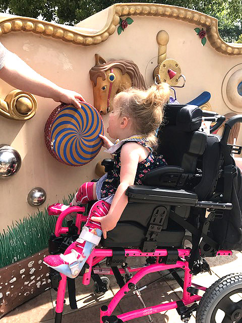 A little girl is playing at the sensory wall