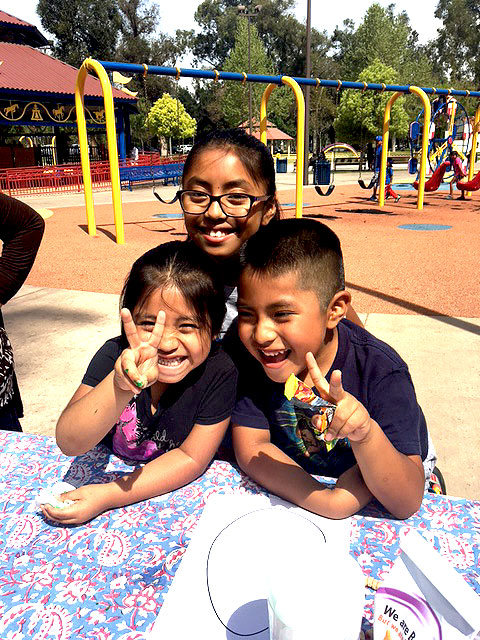 Three children are smiling together at Park Day