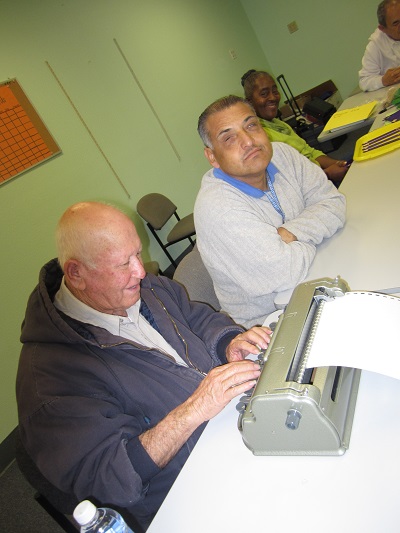 Ramiro learning to type Braille with Ciro.