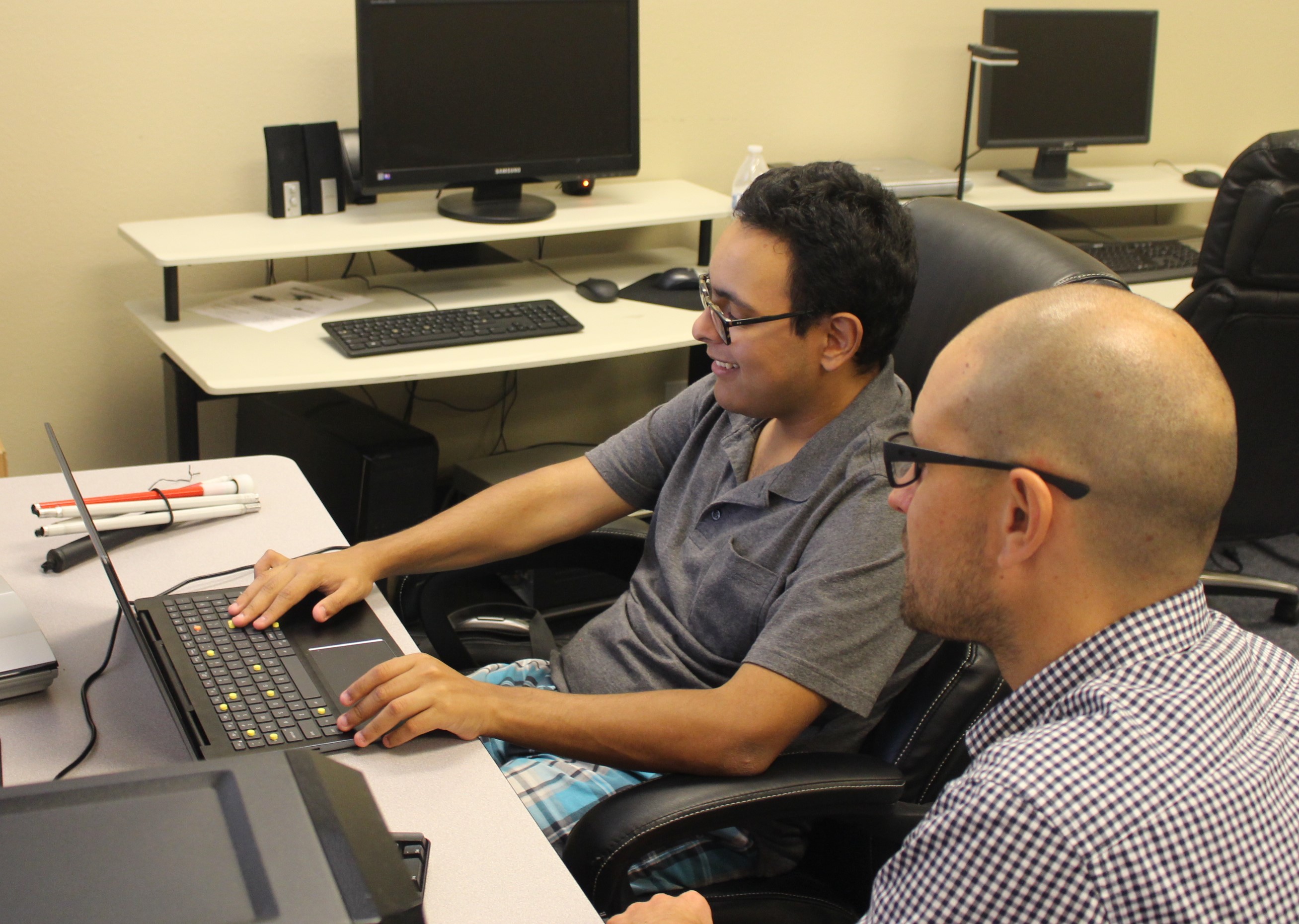 A BSS instructor with their student working on a laptop